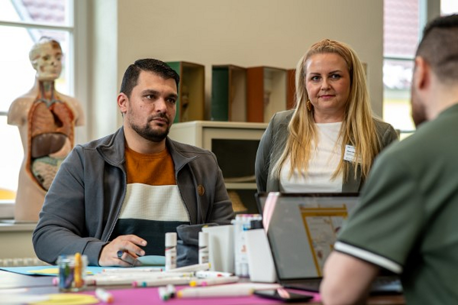 Dozentin in einer Gesprächssituation mit zwei Auszubildenden